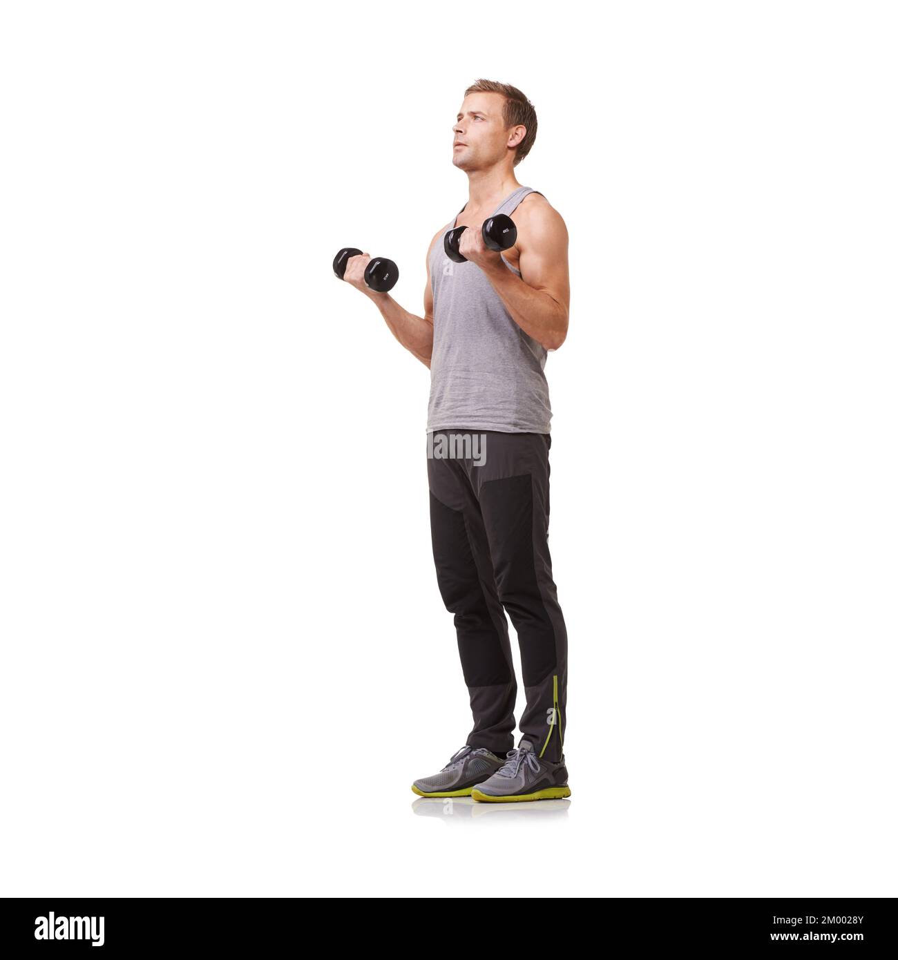 Exercise is part of his daily routine. Full-body of a fit young man doing bicep curls while isolated on a white background. Stock Photo