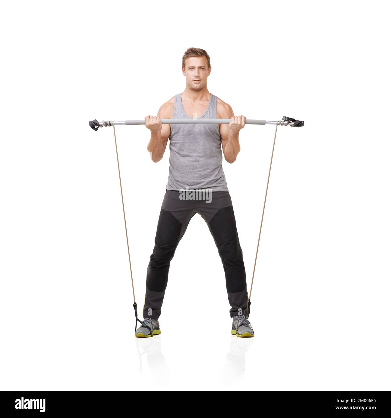 Working towards the body he desires. A young man working his upper body with a resistance band. Stock Photo