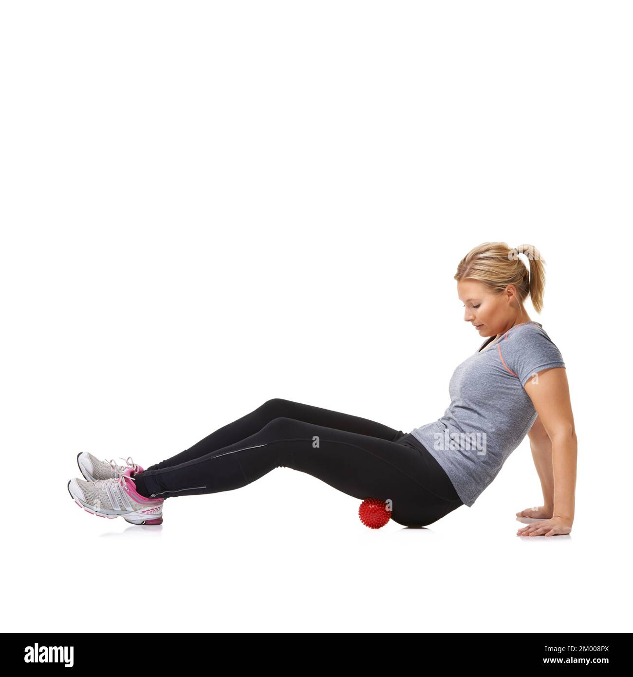 Rolling her glutes. A young woman working out using an exercise ball