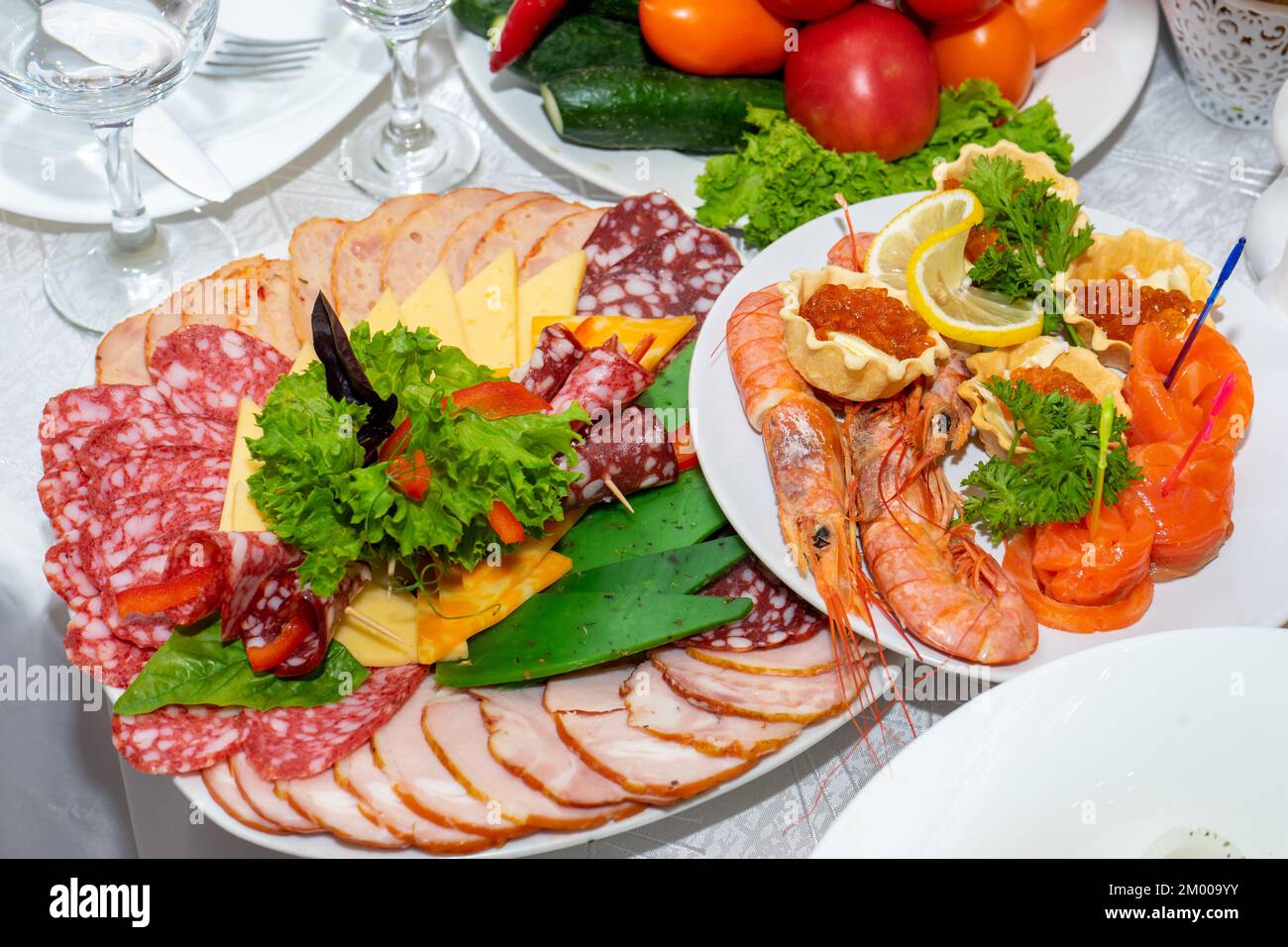Cut meat and seafood on the festive table. Delicious cold snacks are ready to eat. Stock Photo