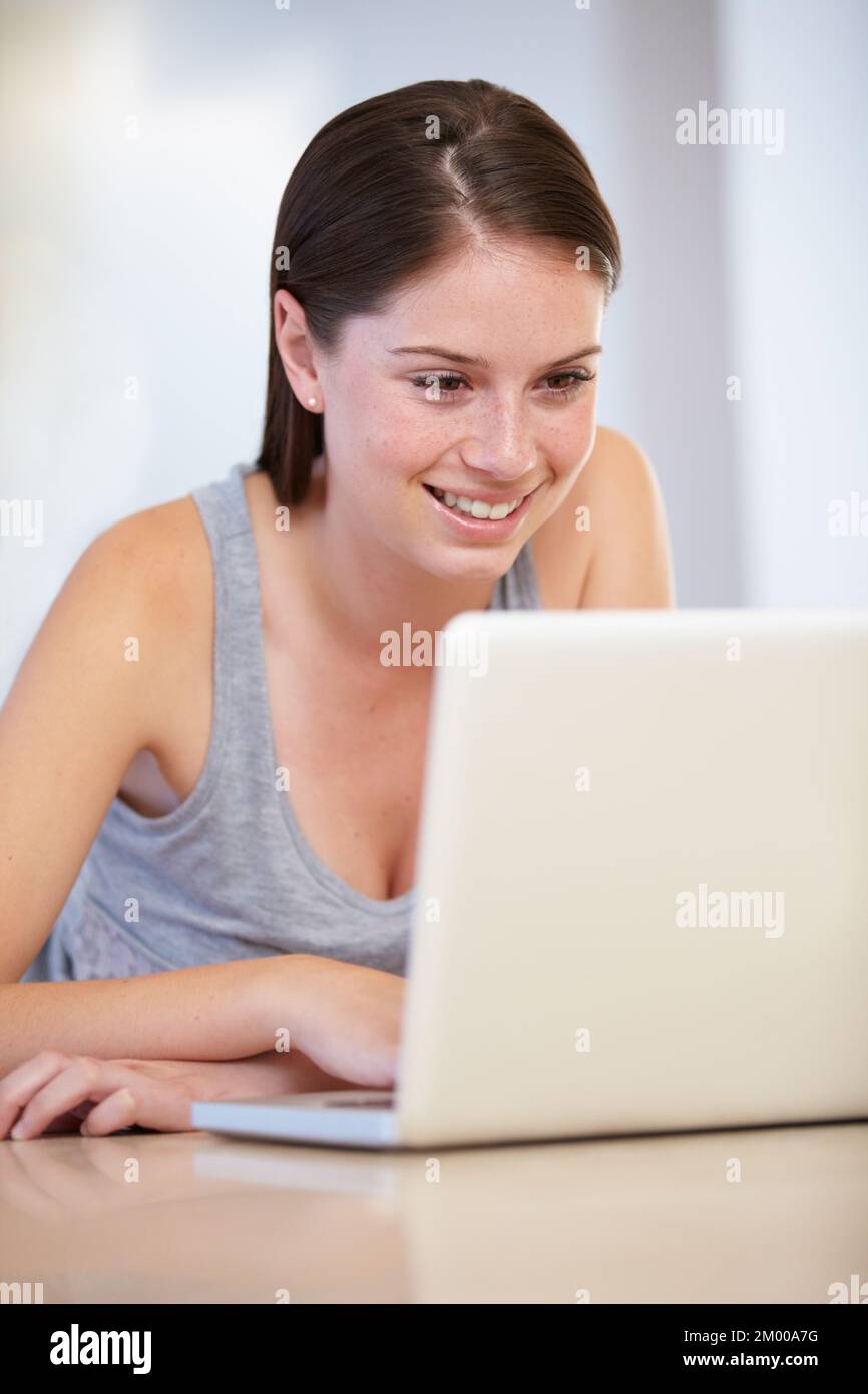Working from home. A gorgeous young woman working on her laptop Stock ...