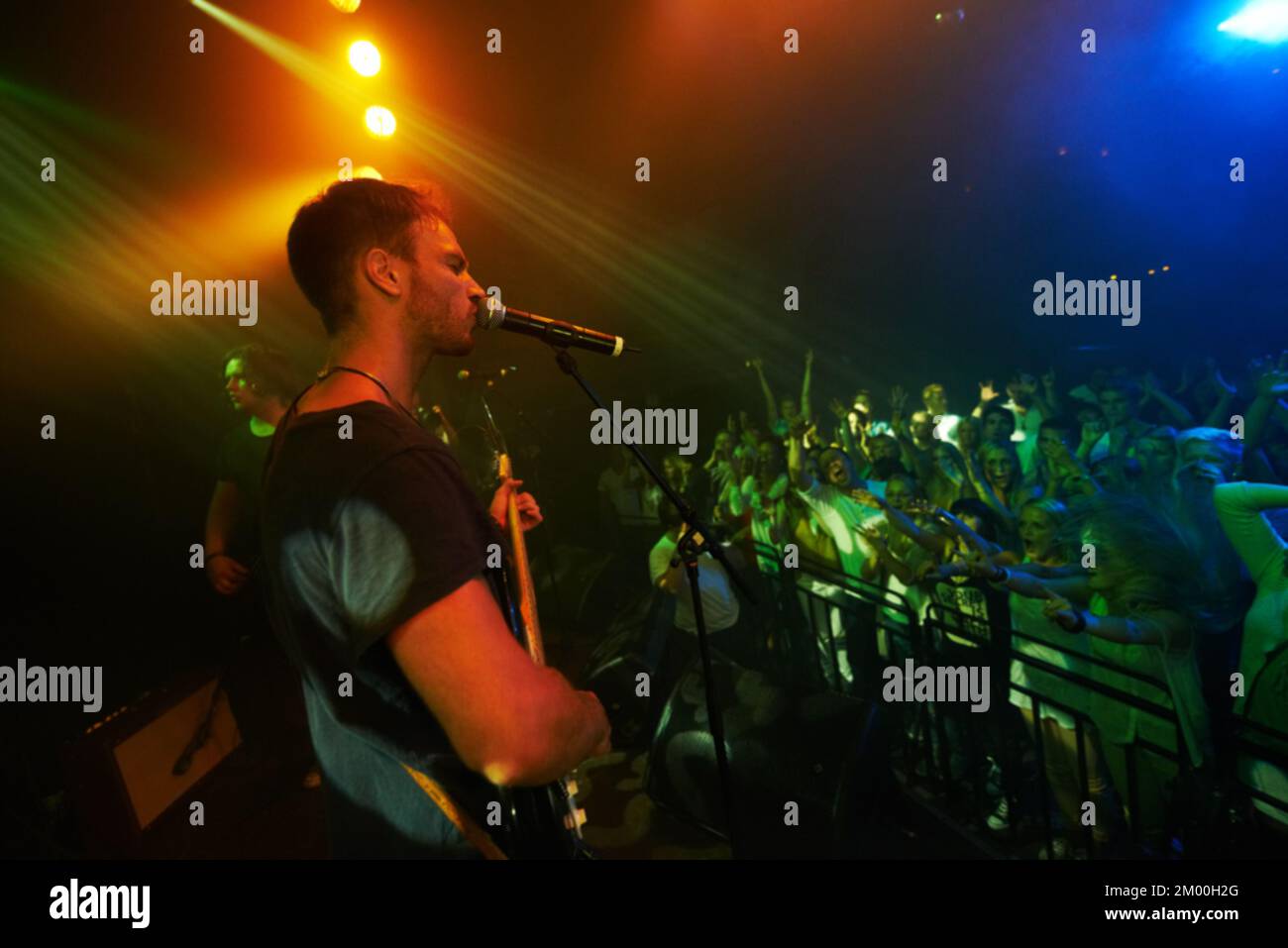 Concert, band and music with a man guitarist playing at a gig for a crowd or audience at a performance event. Festival, stage and social with a male Stock Photo
