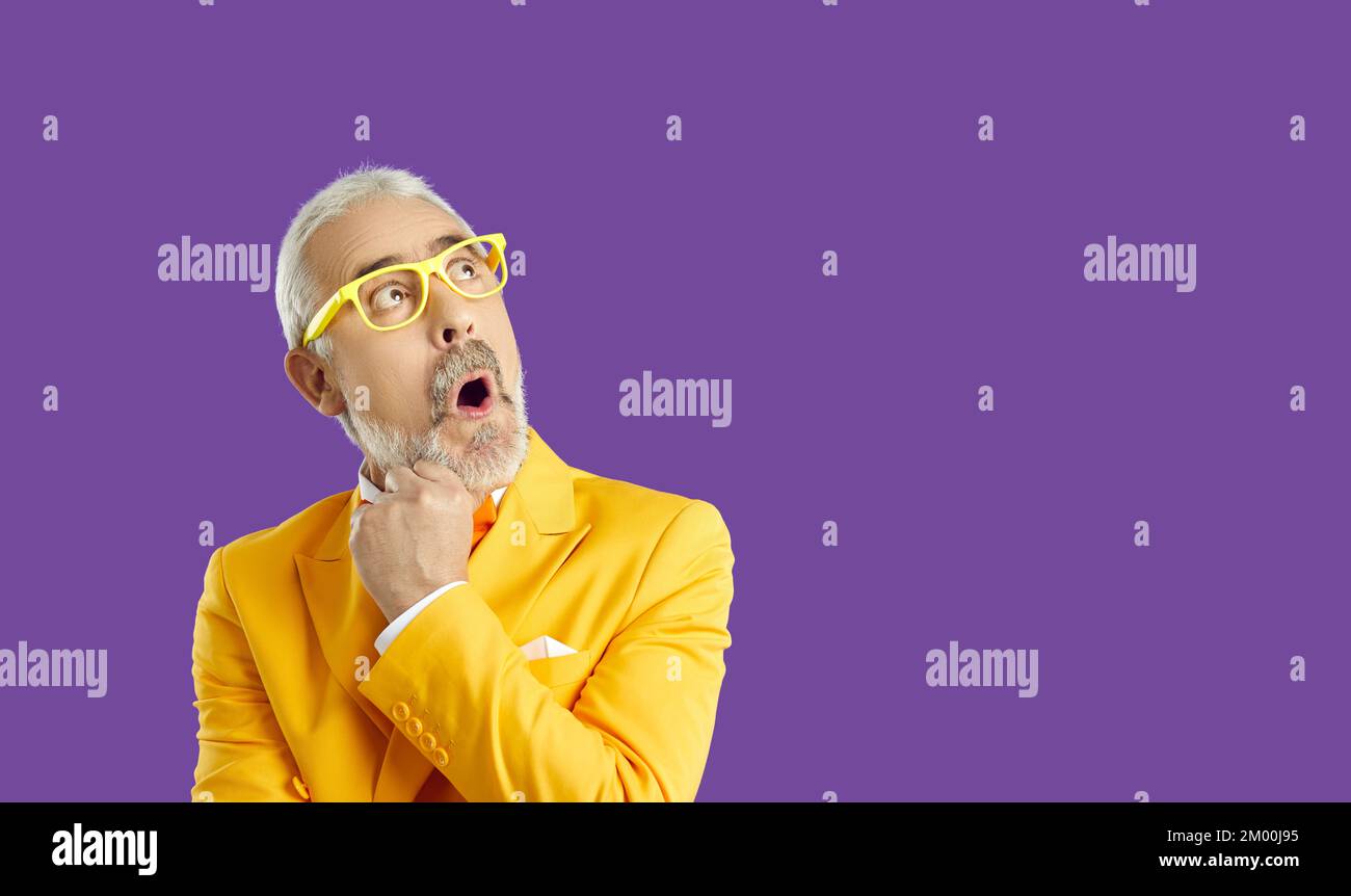 Funny eccentric senior man with amazed and shocked facial expression on banner background. Stock Photo