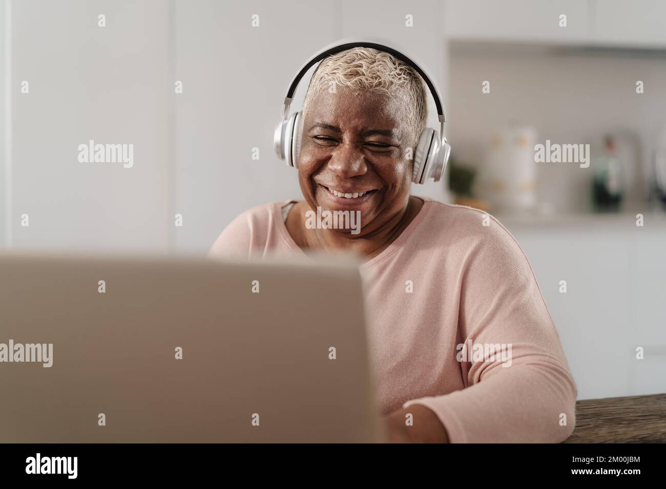 Happy senior woman having fun using a laptop in her house - Technology and smart working concept Stock Photo