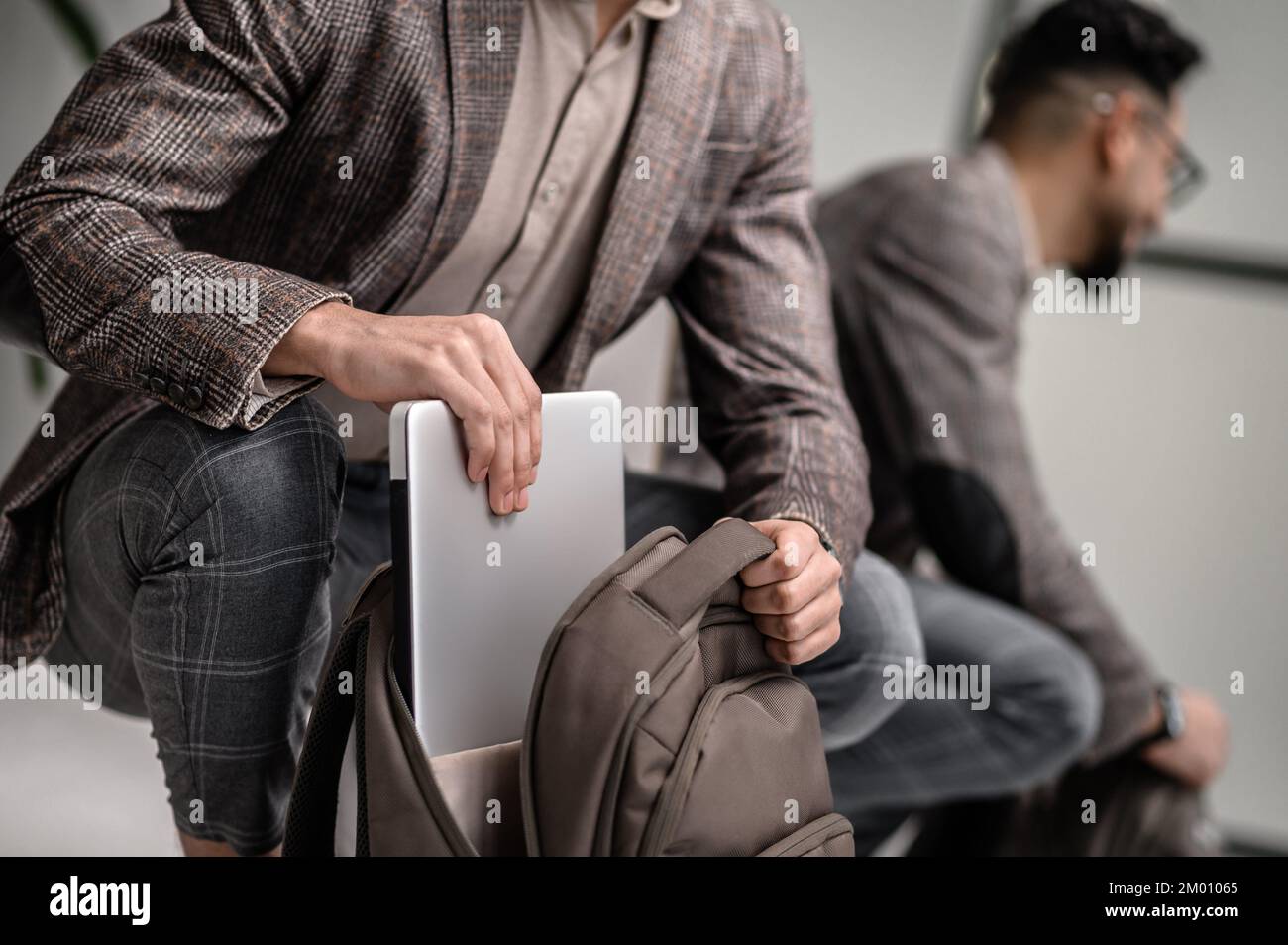 Packing a backpack. A stylish man apacking his backpack before leaving