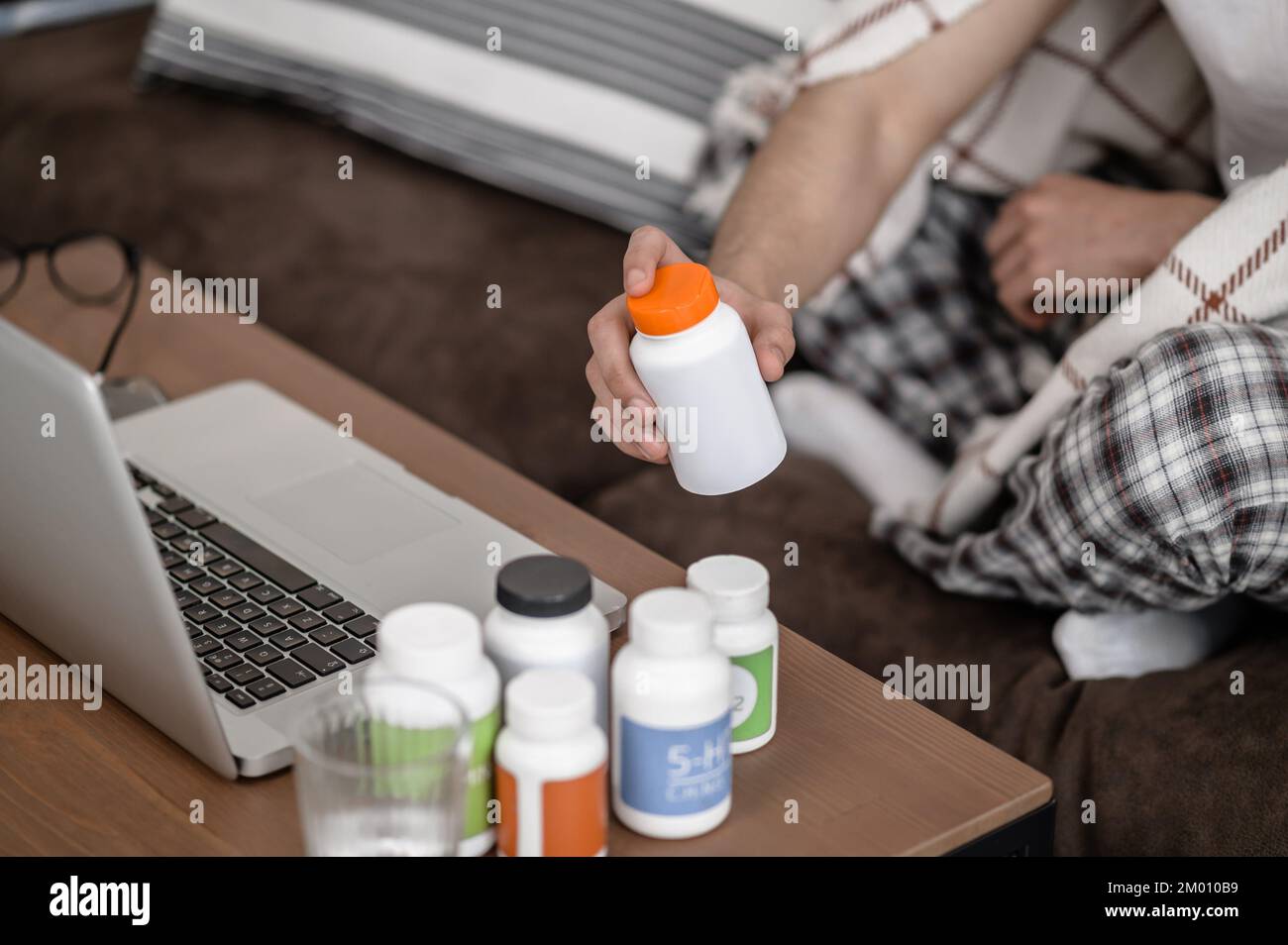 Feeling sick. A man feeling unwell and taking pills. Stock Photo