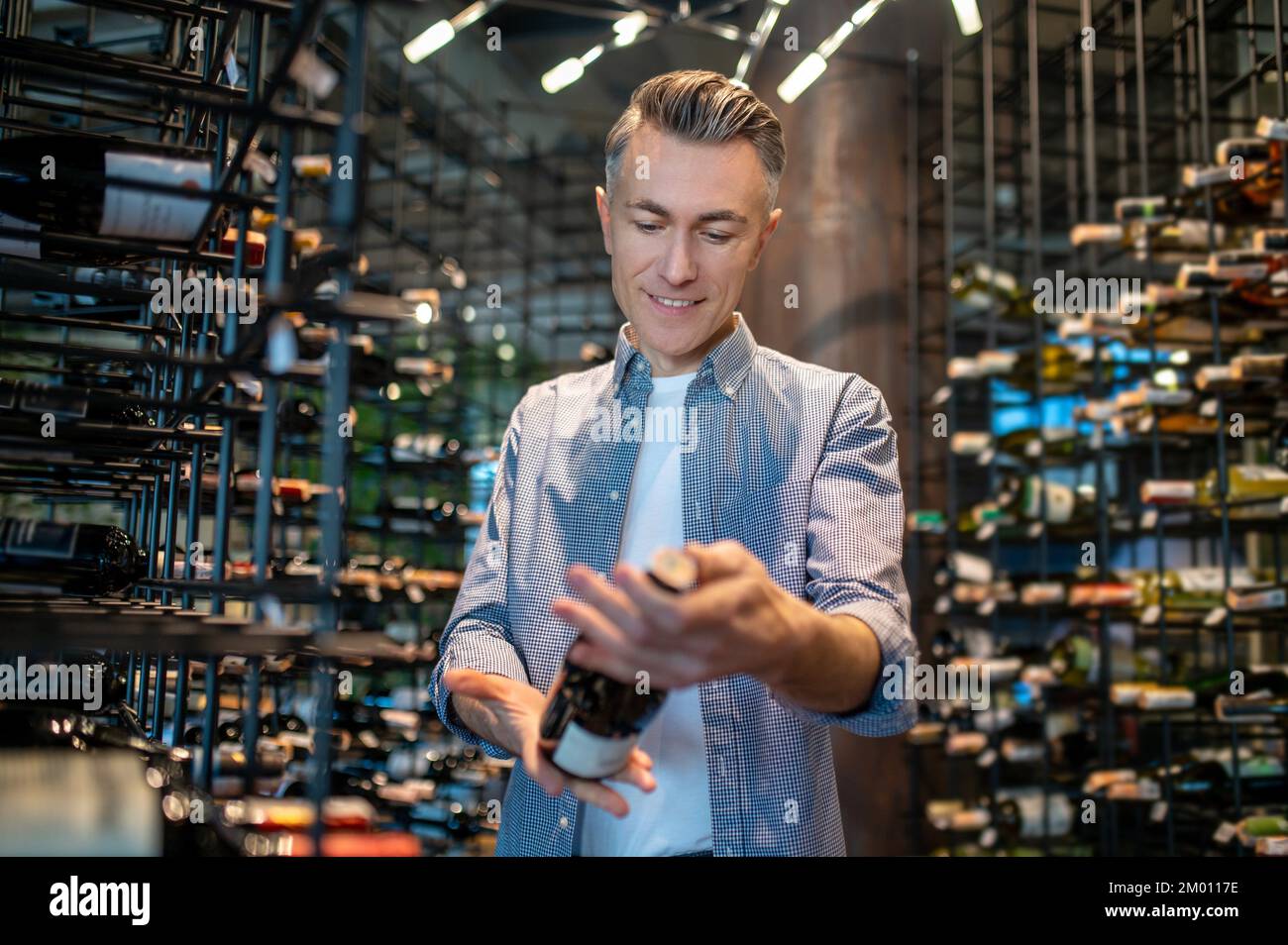 Revision. A wine store owner making a revision and looking involved Stock Photo Alamy