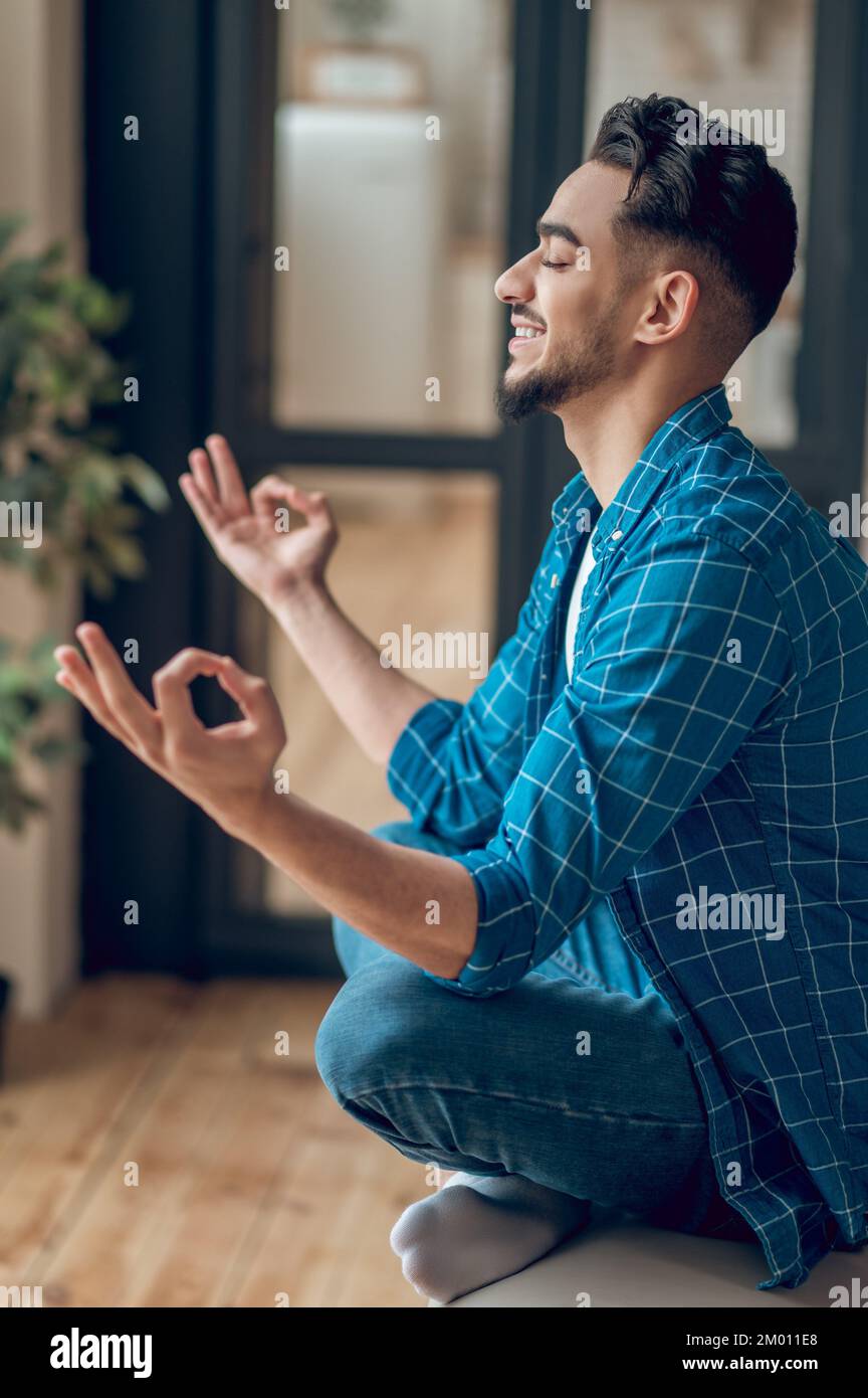 Meditation. Positive young yogi sitting in lotus pose with fingers in giana mudra. Stock Photo