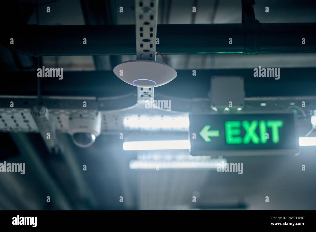 Optical smoke detector mounted on the ceiling beside the illuminated