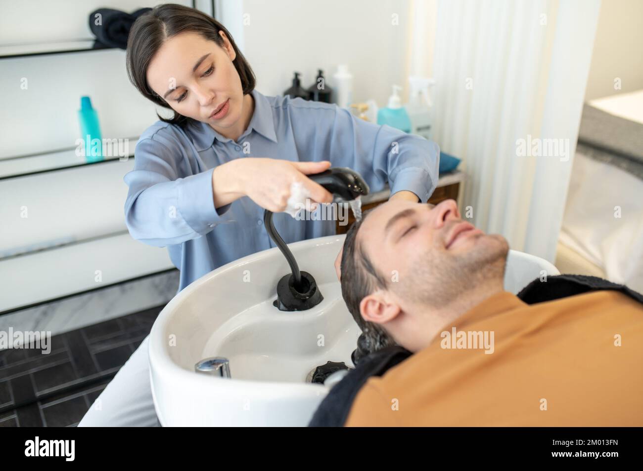 Hair wash. Hairdresser washing hair to the male client in a beauty salon Stock Photo Alamy