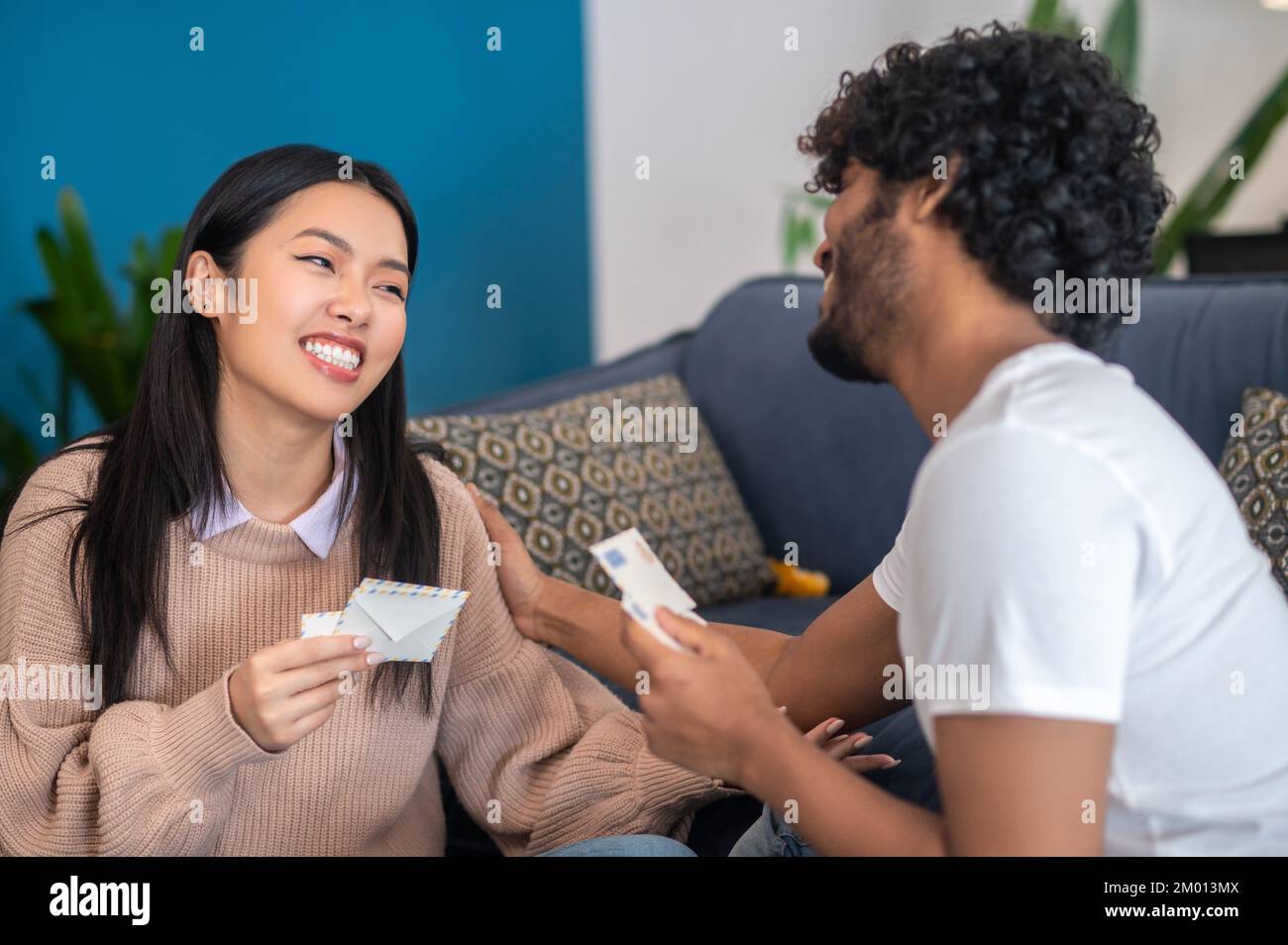 Correspondence. Young people sitting on the floor with envelopes in