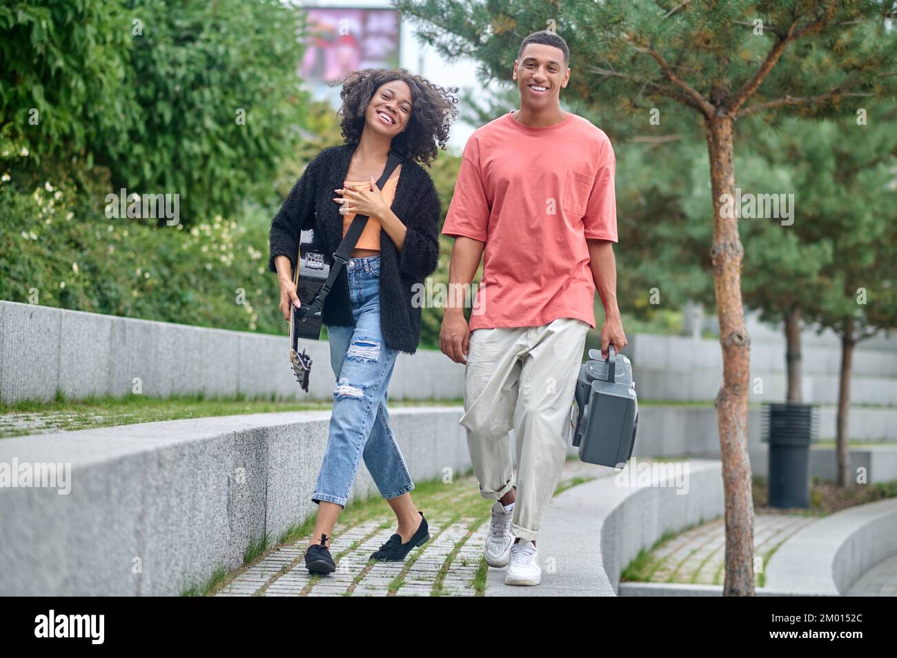 Great day. Happy darkskinned guy with tape recorder and girl with