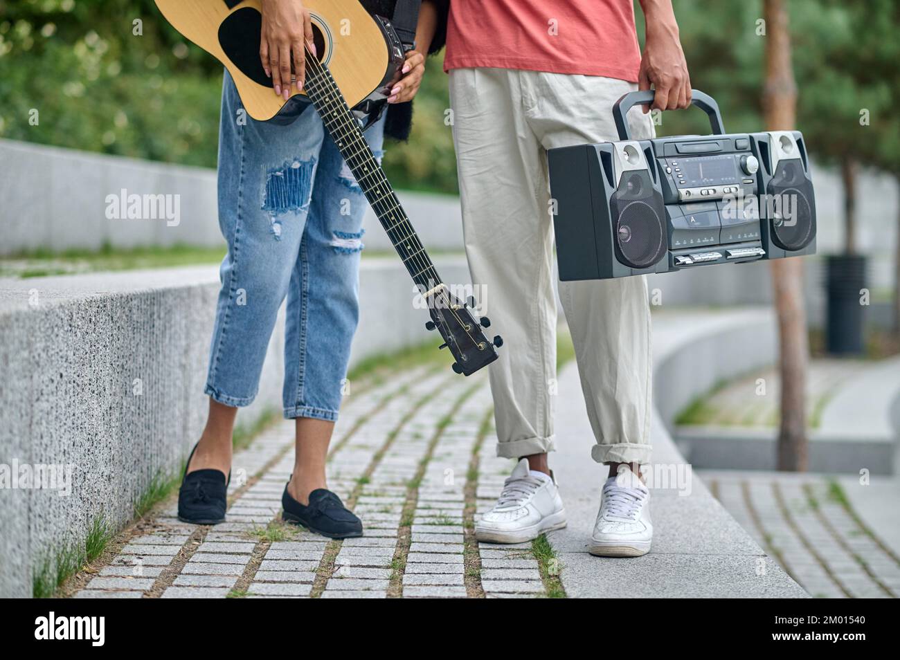 Life style. Guitar and tape recorder in hands of young darkskinned guy