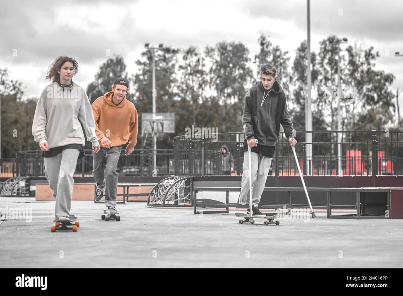 Hobby. Girl redhaired guy and friend on crutches riding skateboards in
