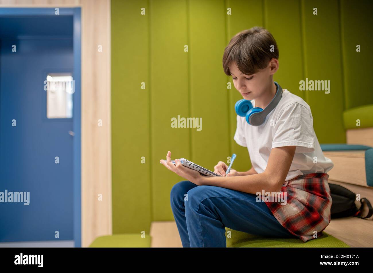 At school. A schoolboy writing something and looking involved. Stock Photo