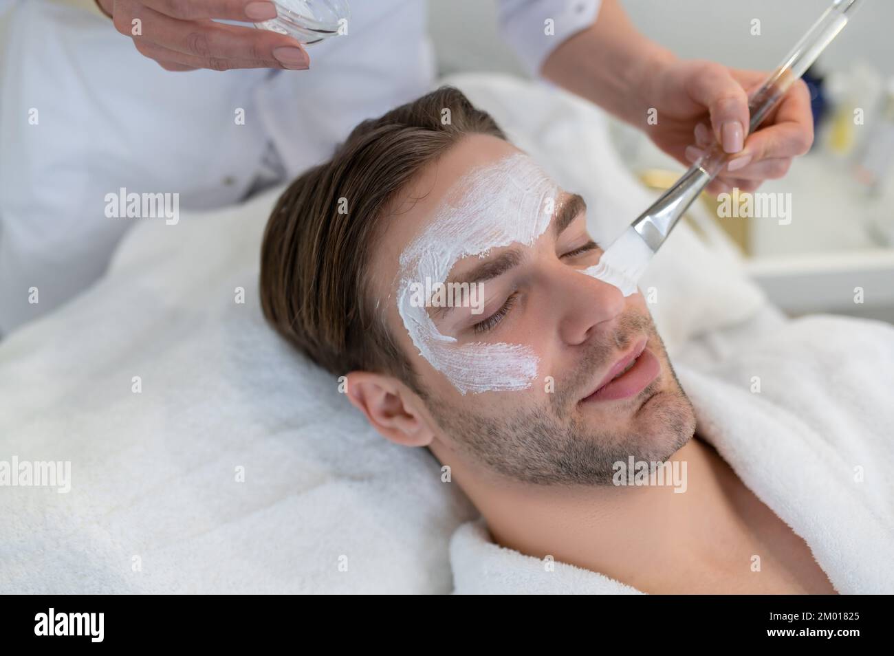 Face care. Close up of a man with a moisturizing mask on his face. Stock Photo