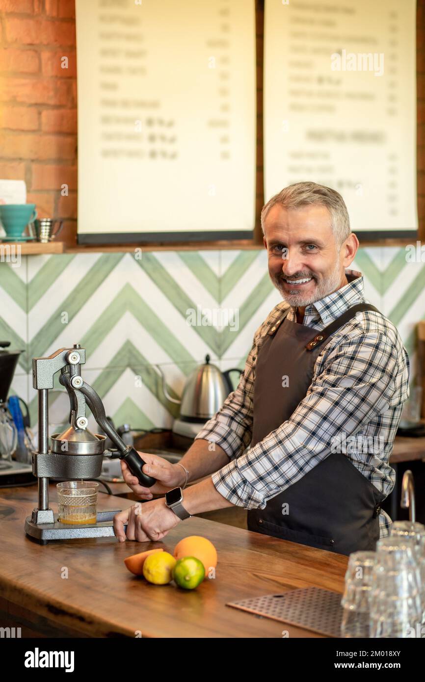 Making juice. Man in plaid shirt standing near juicer and making juice Stock Photo Alamy