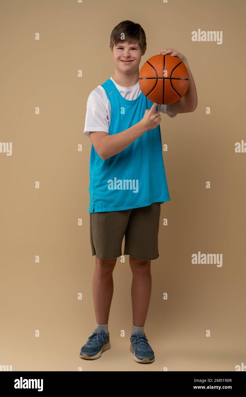 Fullsize portrait of a smiling teenager spinning the game ball on the
