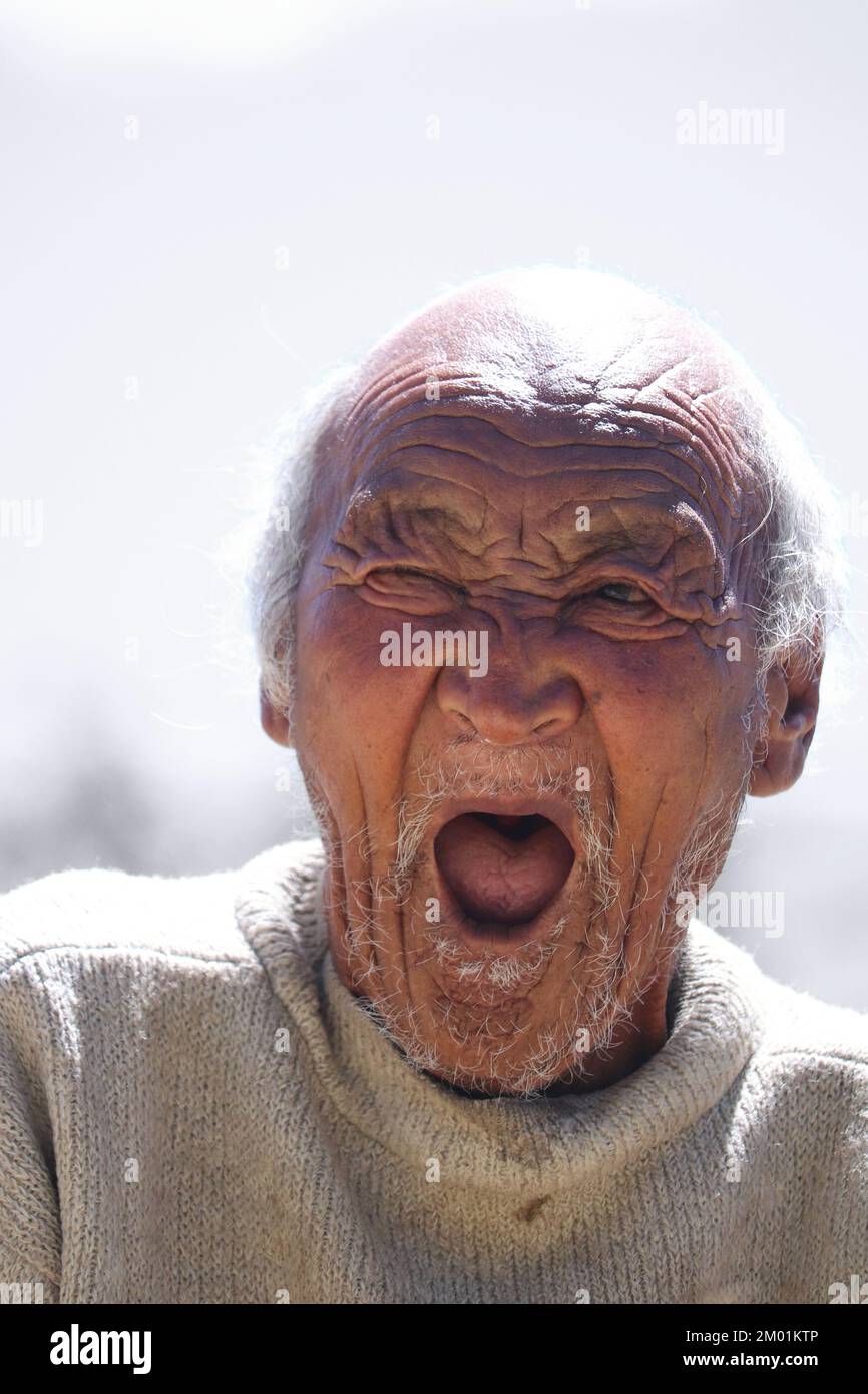 Grey haired senior man wearing casual white sweeter standing over isolated background bored yawing tired mouth, Restless and sleepiness Stock Photo