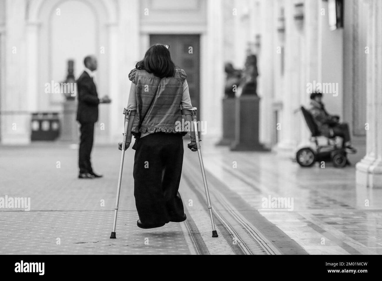 Shallow depth of field (selective focus) details with a woman using crutches. Stock Photo