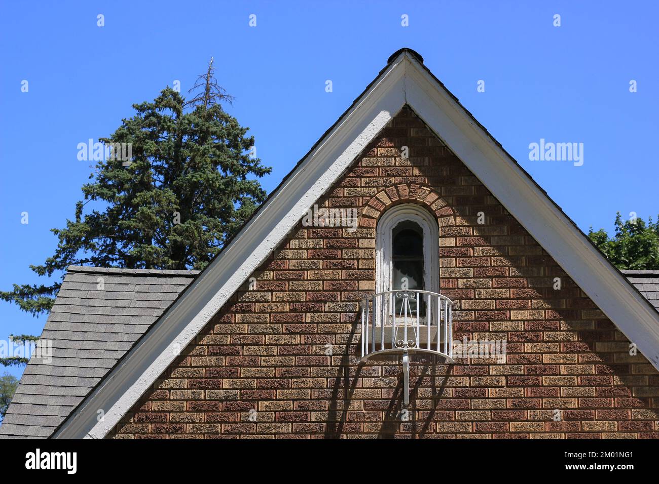 Pointed rooftop of a traditional vintage colonial brick home and