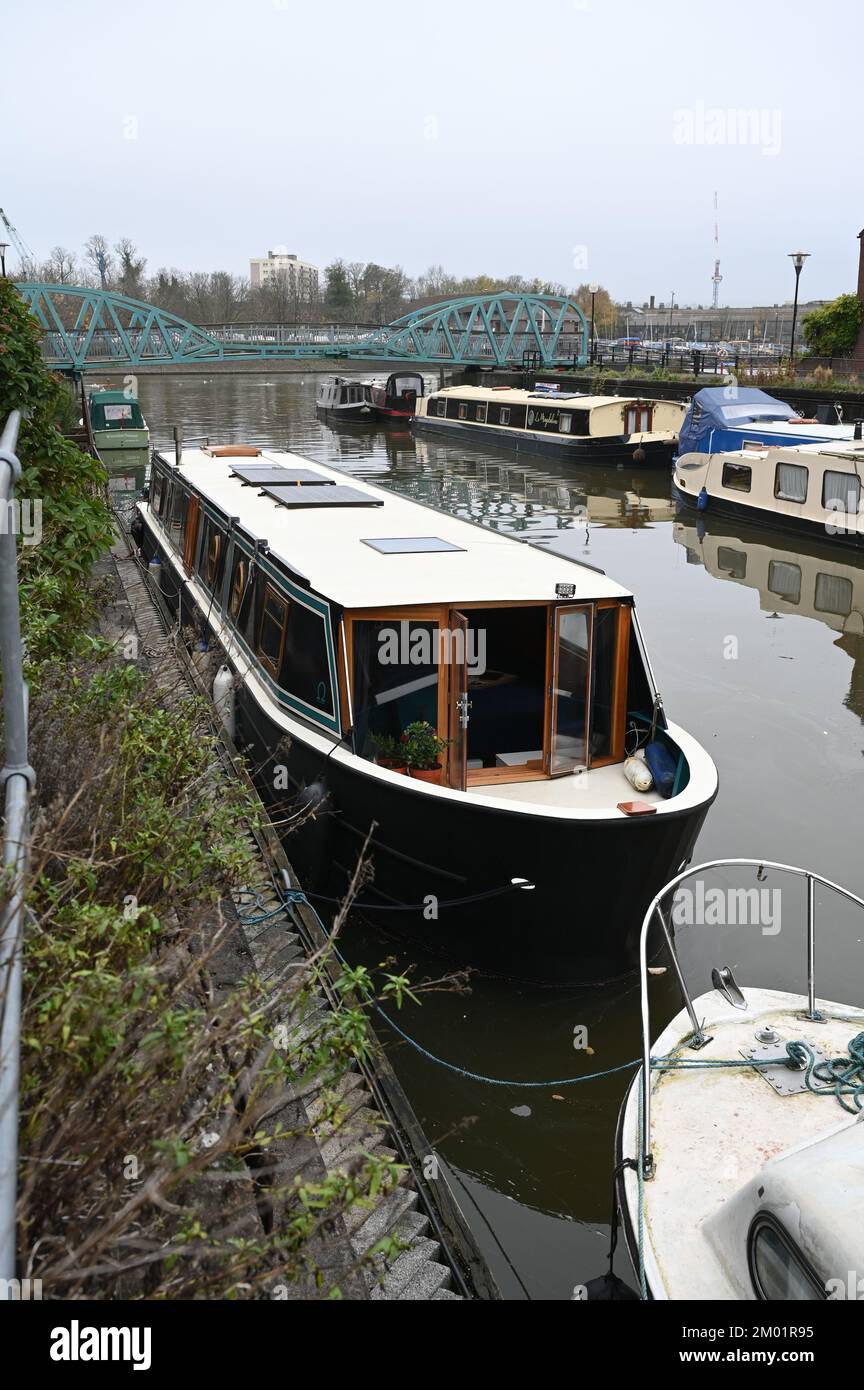 A distinctive widebeam boat called Good Ohmen moored close to houses adjacent to Bristol Docks. Stock Photo