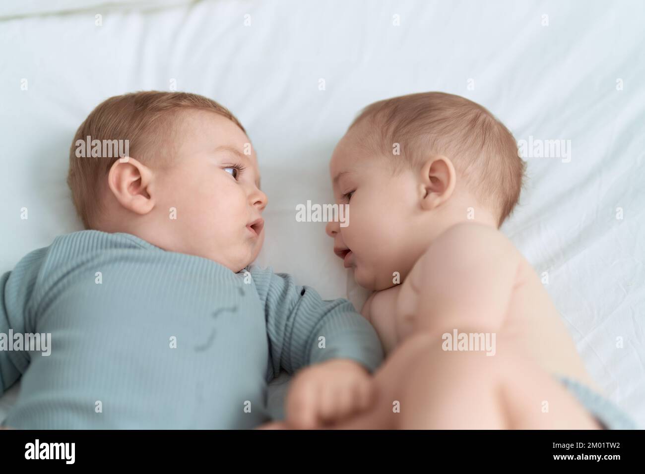 Two toddlers lying on bed at bedroom Stock Photo Alamy
