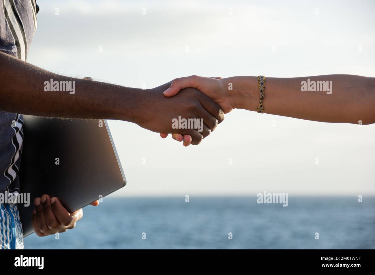 Handshake between African boy and Caucasian girl, partnership concept Stock Photo