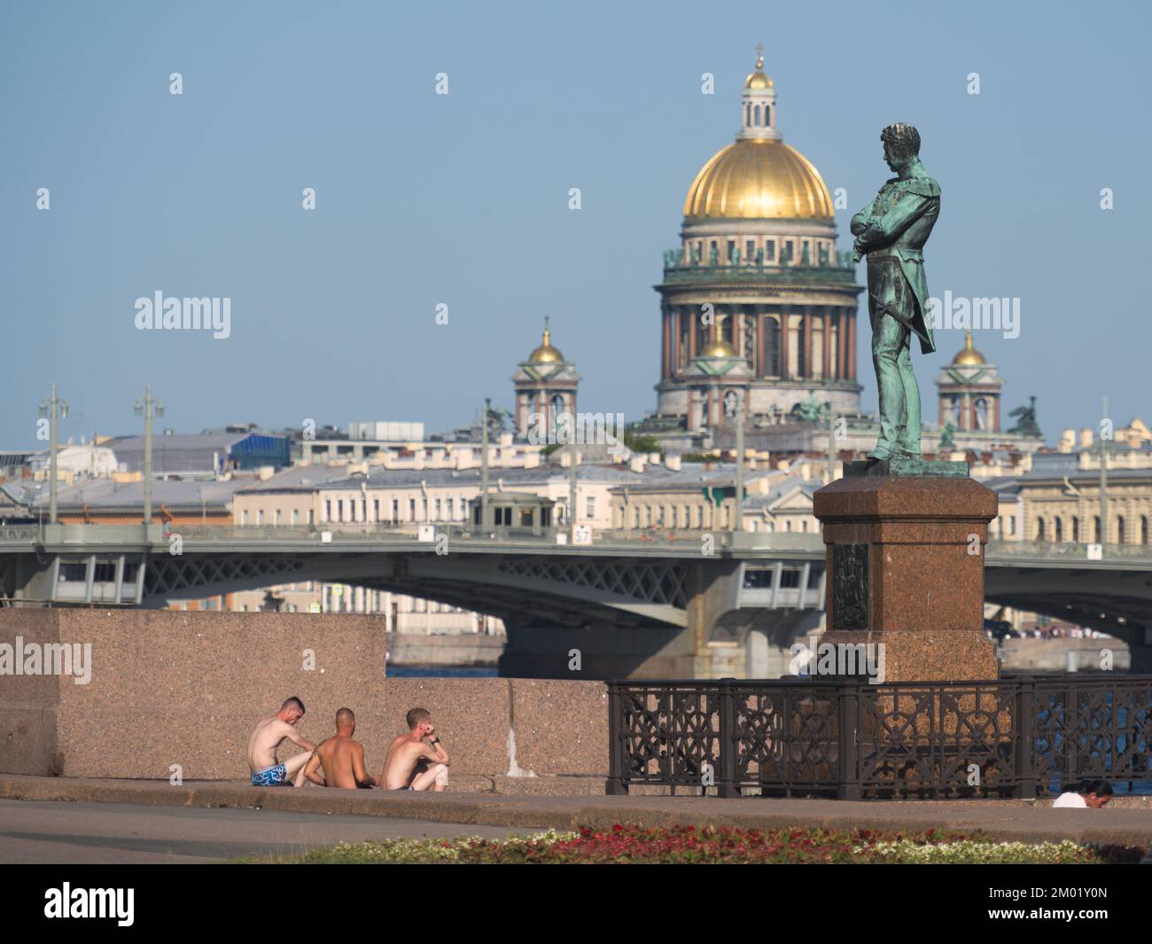 Summer heat in St. Petersburg, Russia: young people sitting at the monument to Ivan Krusenstern after bathing in Neva river Stock Photo