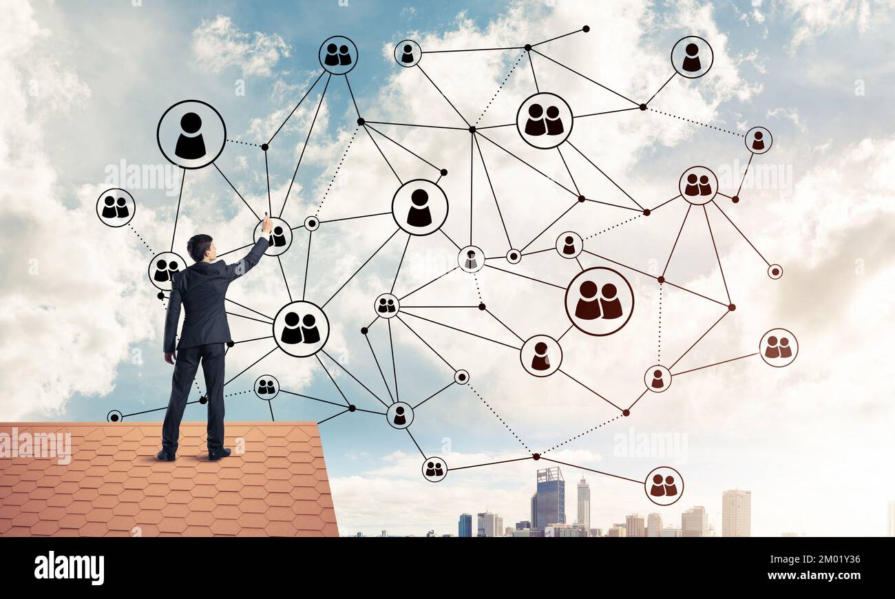 Businessman on house roof presenting networking and connection c Stock ...