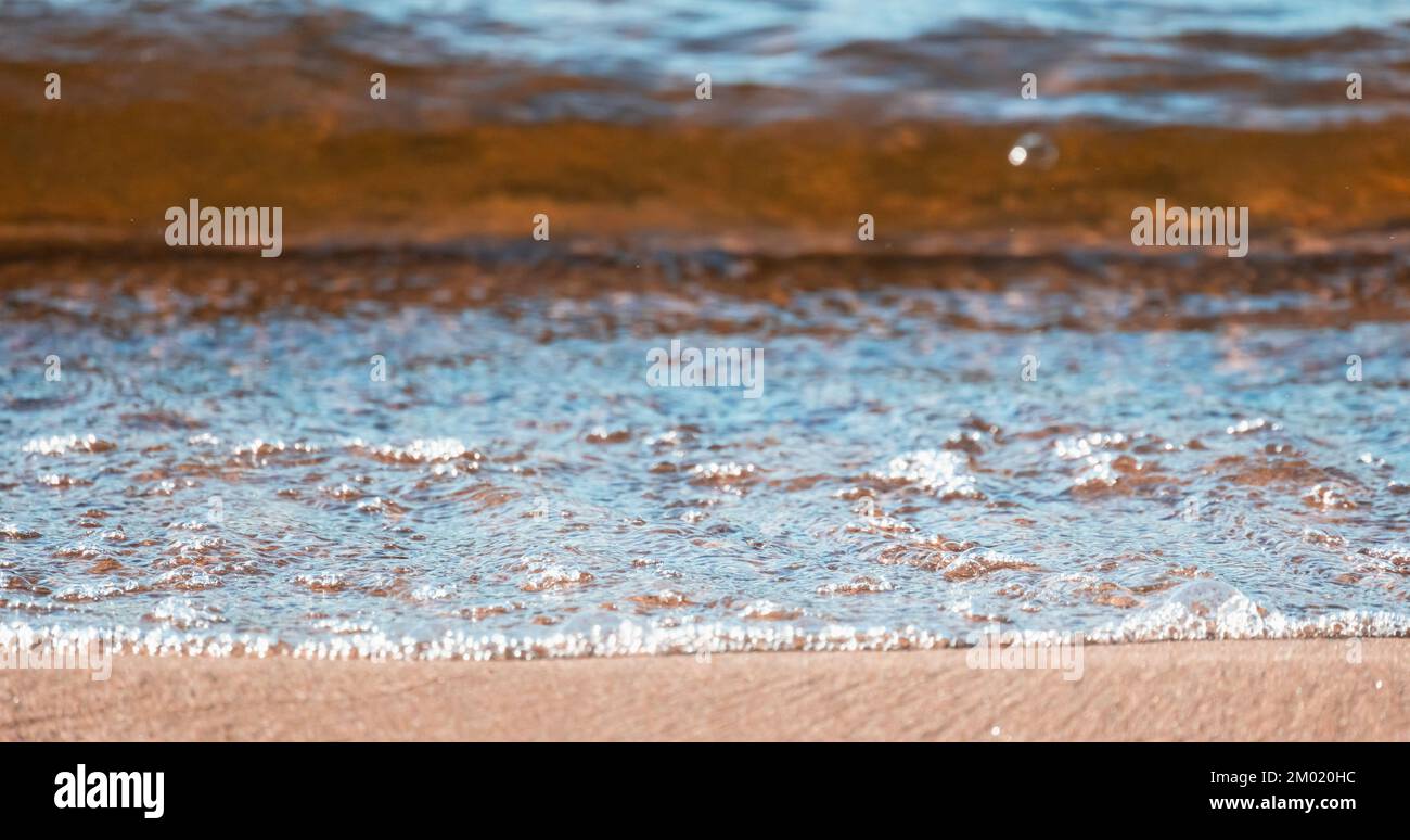 Baltic Sea shore water with sand and foam. Abstract natural panoramic background photo with selective soft focus Stock Photo