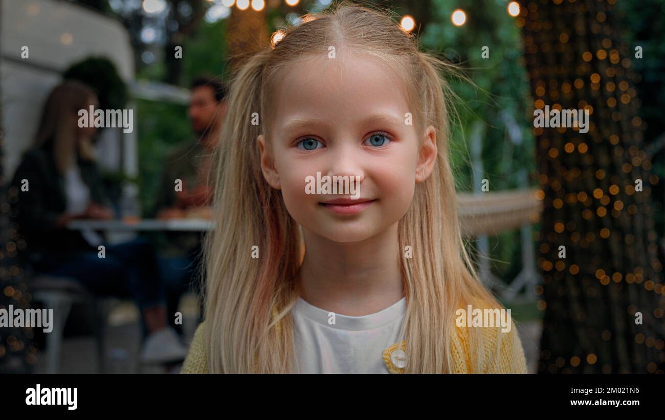 Portrait small little kid 10s girl child baby Caucasian schoolgirl daughter looking camera waving hand hello hi bye greeting background of parents mom Stock Photo