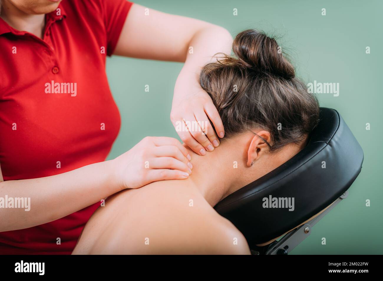 Chair massage. Therapist massaging womans neck for stress and tension relief Stock Photo