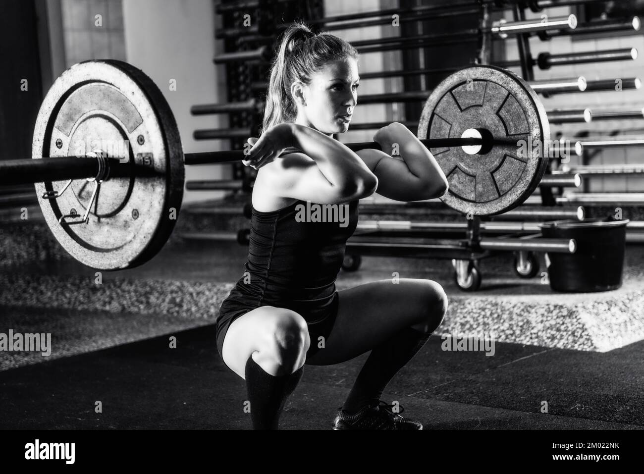 Female athlete lifting heavy barbells. Stock Photo