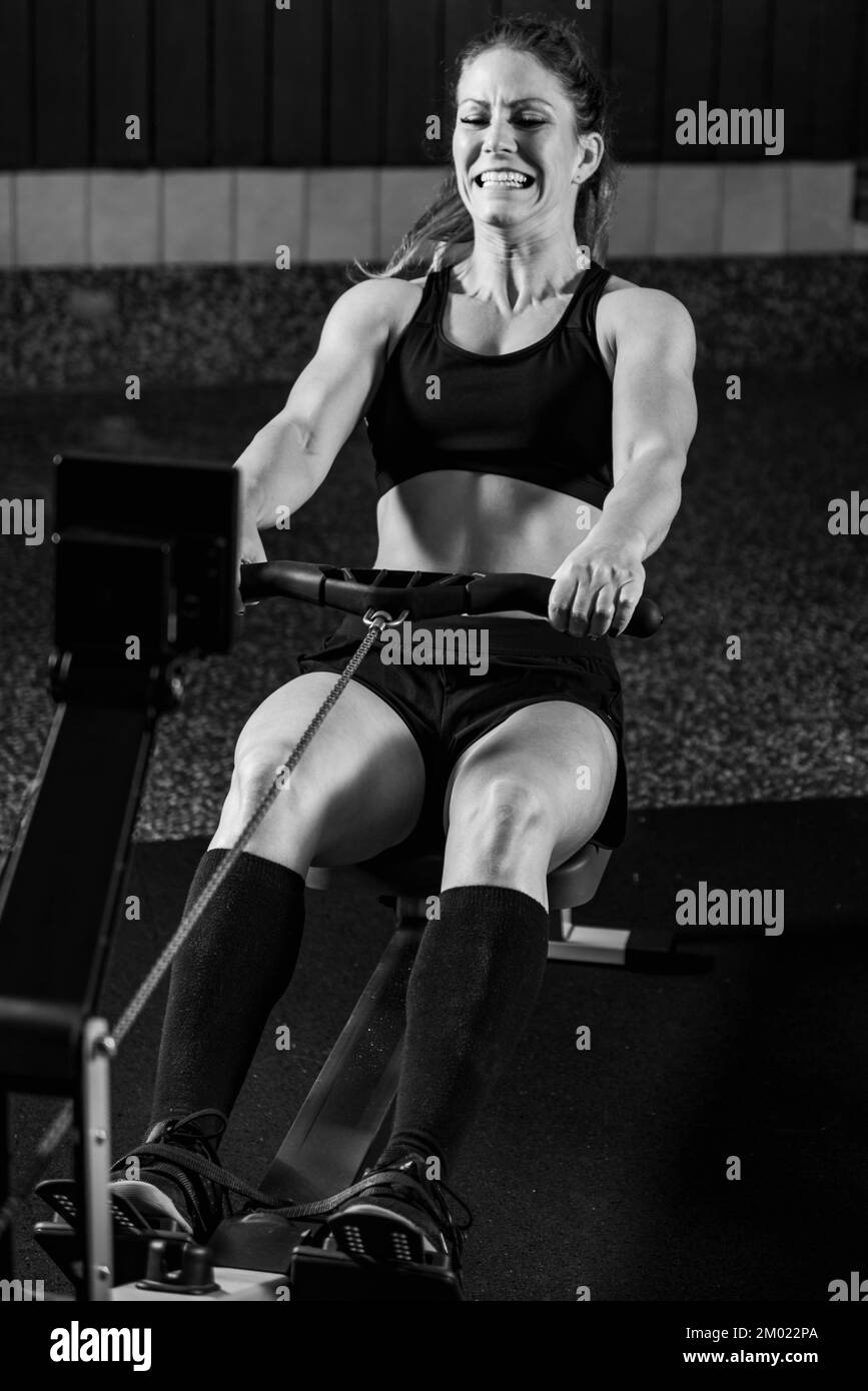 Woman using a rowing machine Stock Photo