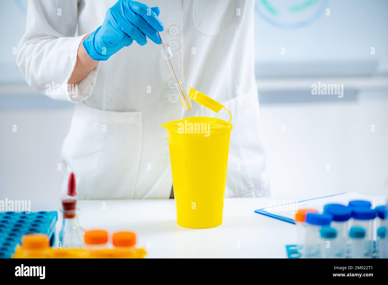 Throwing away medical waste in a hazardous waste container Stock Photo