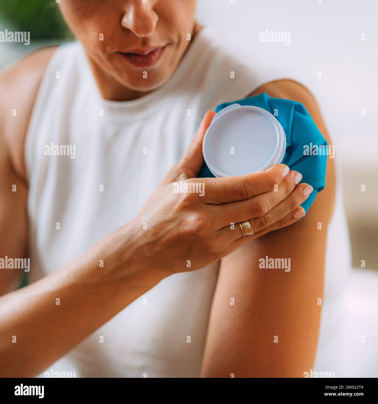 Woman pressing cold compress to shoulder Stock Photo