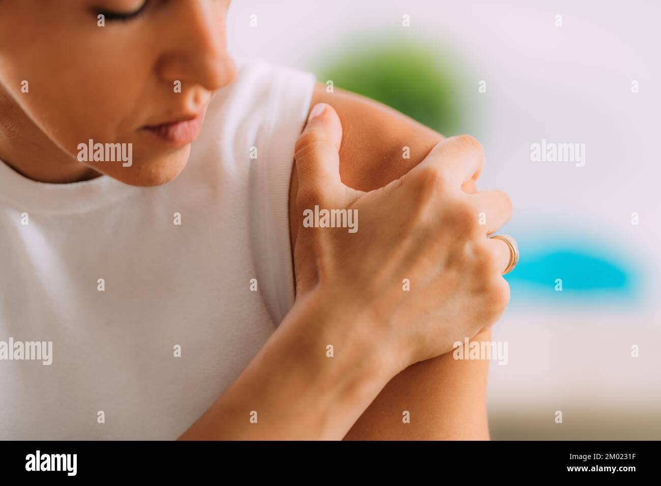 Woman holding onto painful shoulder. Stock Photo