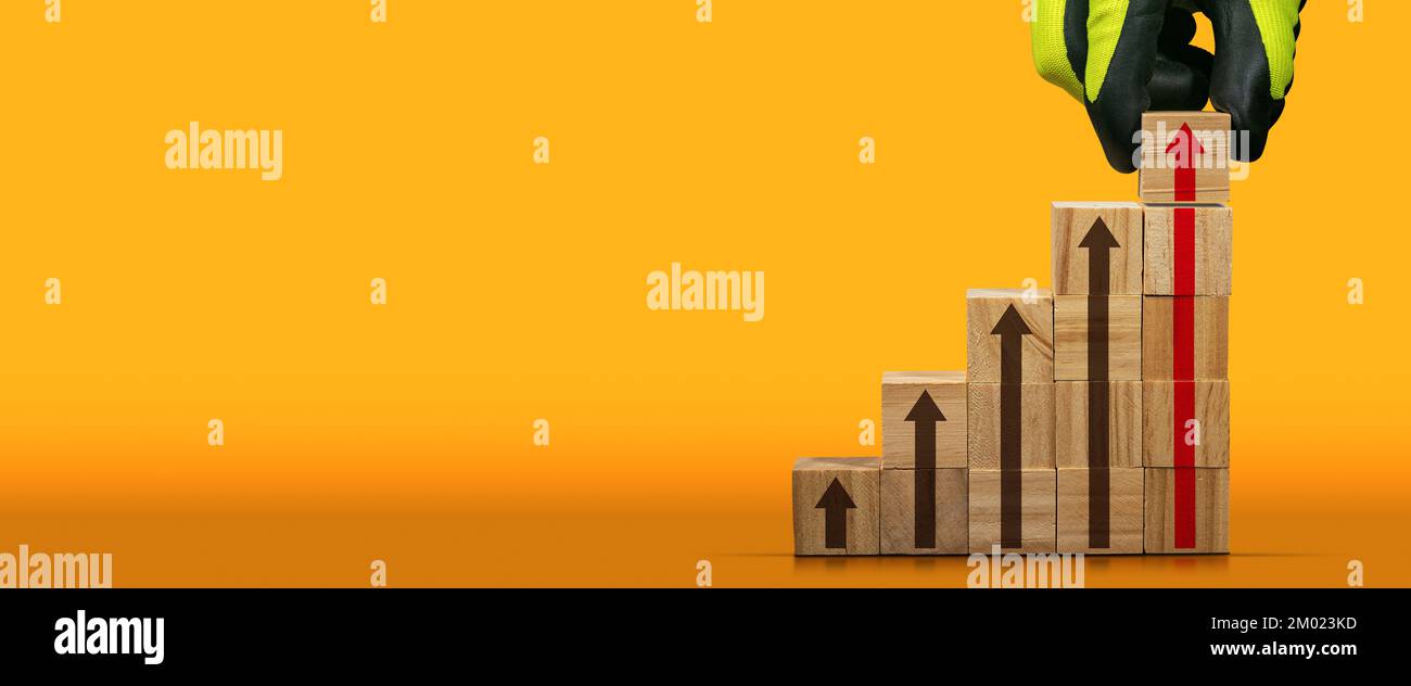 Gloved hand arranging wood blocks as step stair with arrow symbols, on ...