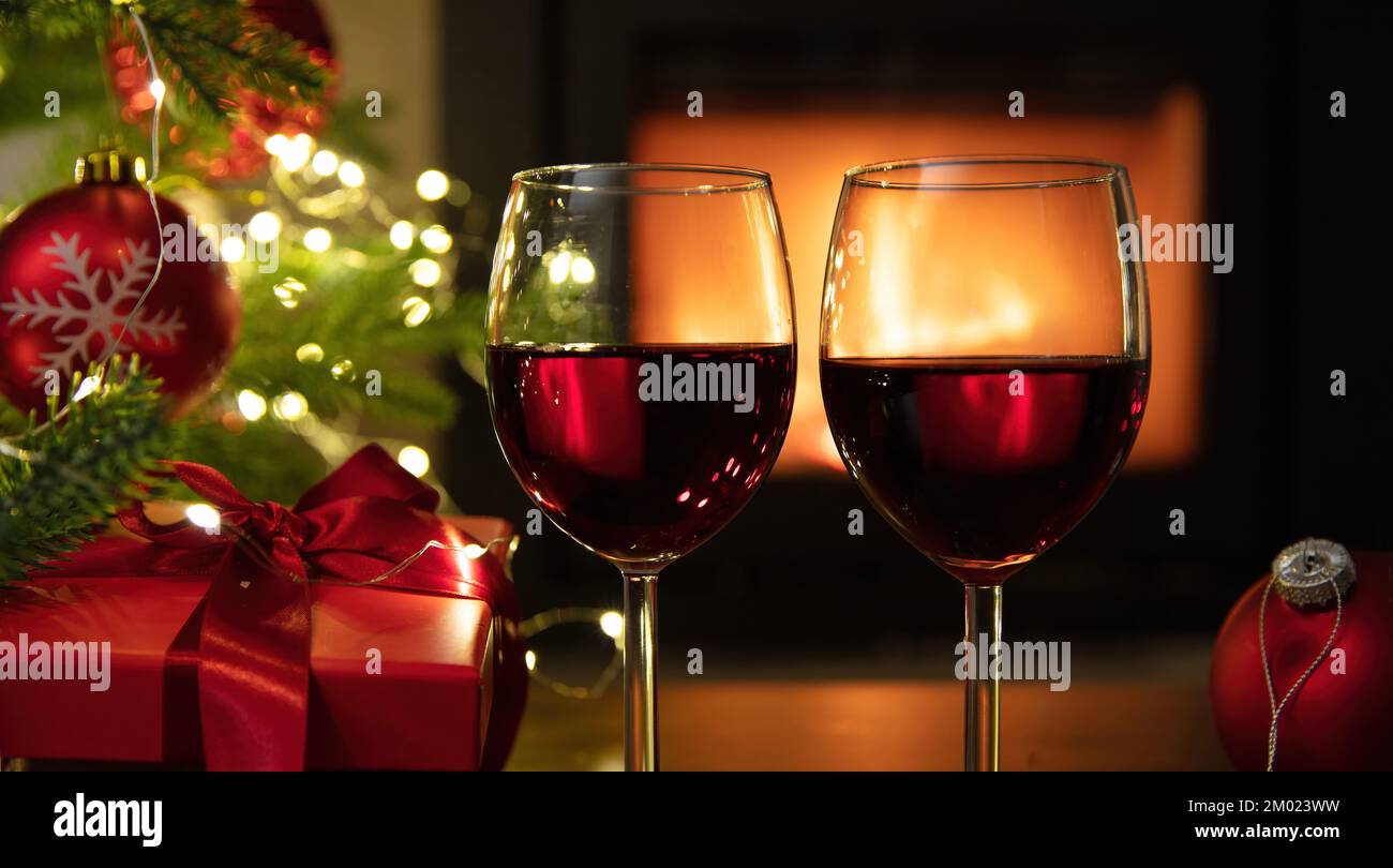 Christmas celebration. Two red wine glasses Xmas presents and