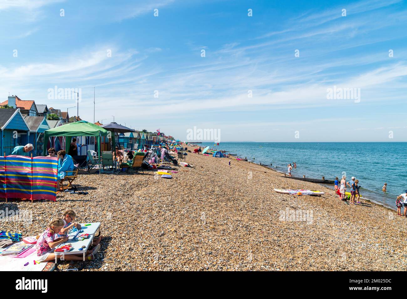 view-along-herne-bay-beach-on-a-hot-summer-s-day-beach-huts-painted