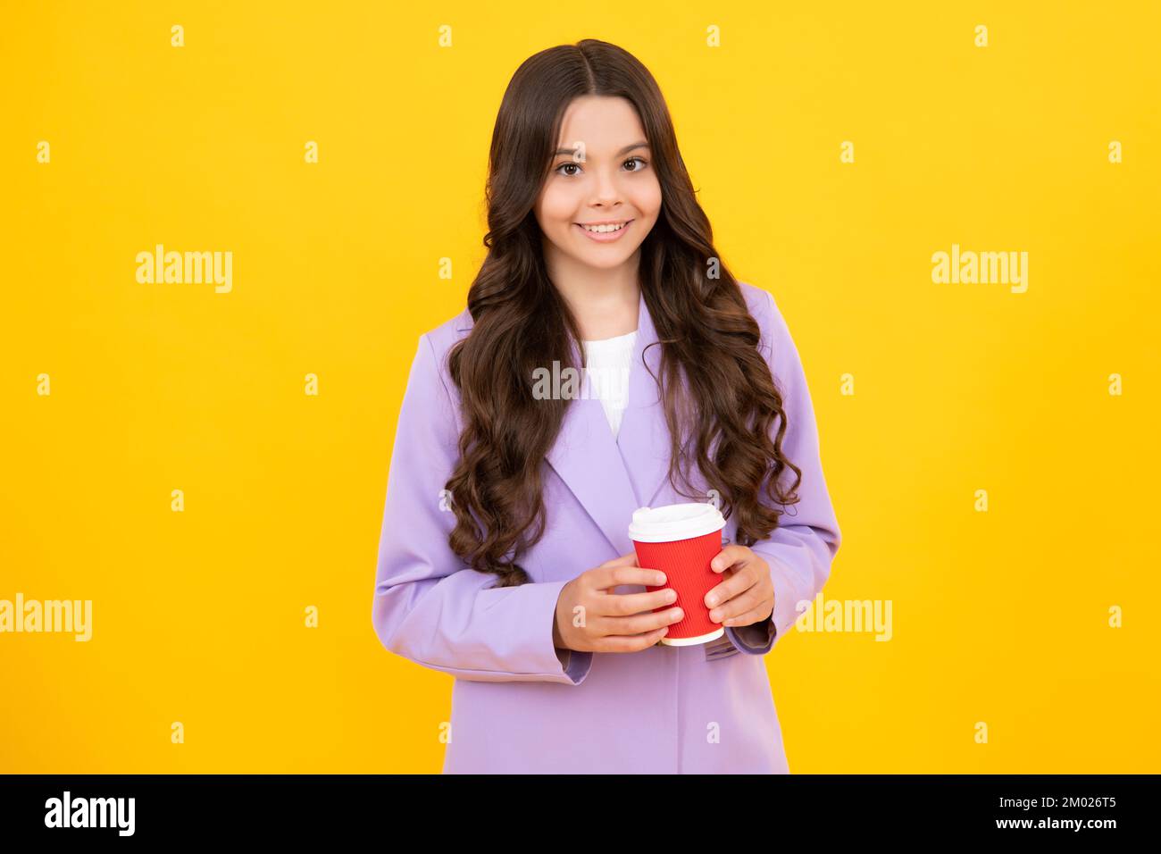 Teenage girl with take away cup of cappuccino coffee or tea. Child with takeaway cup on yellow background, morning drink beverage. Happy face, positiv Stock Photo