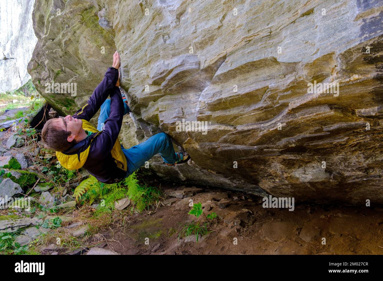 Athlete climbing rock. Male rock climber bouldering in Switzerland