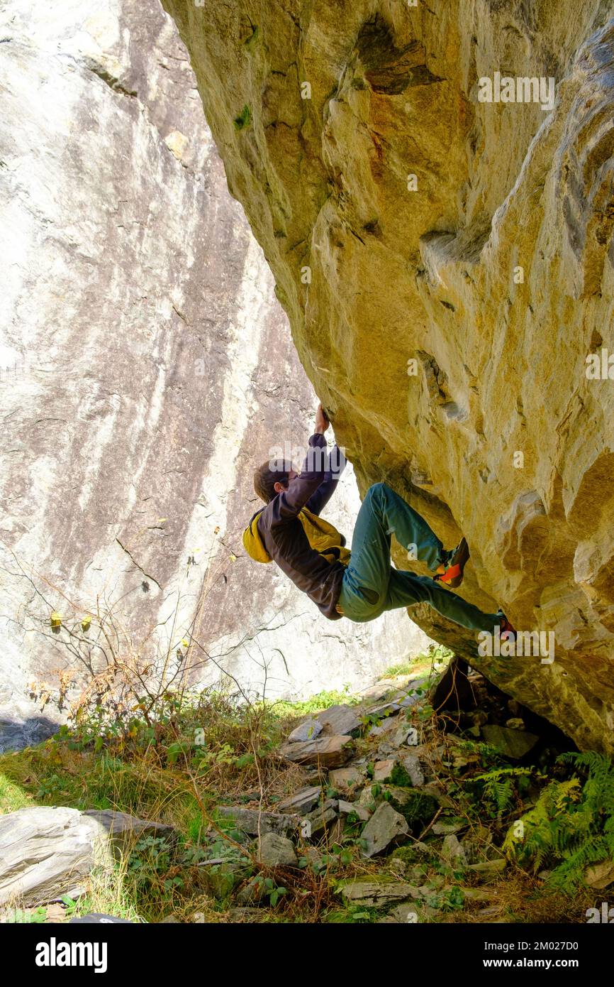Athlete climbing rock. Male rock climber bouldering in Switzerland Stock Photo