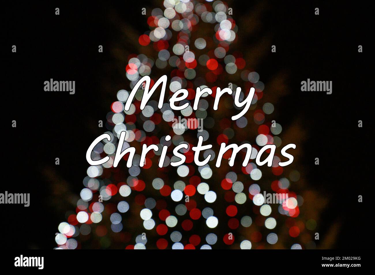 Merry Christmas text card with colorful bokeh background. Stock Photo