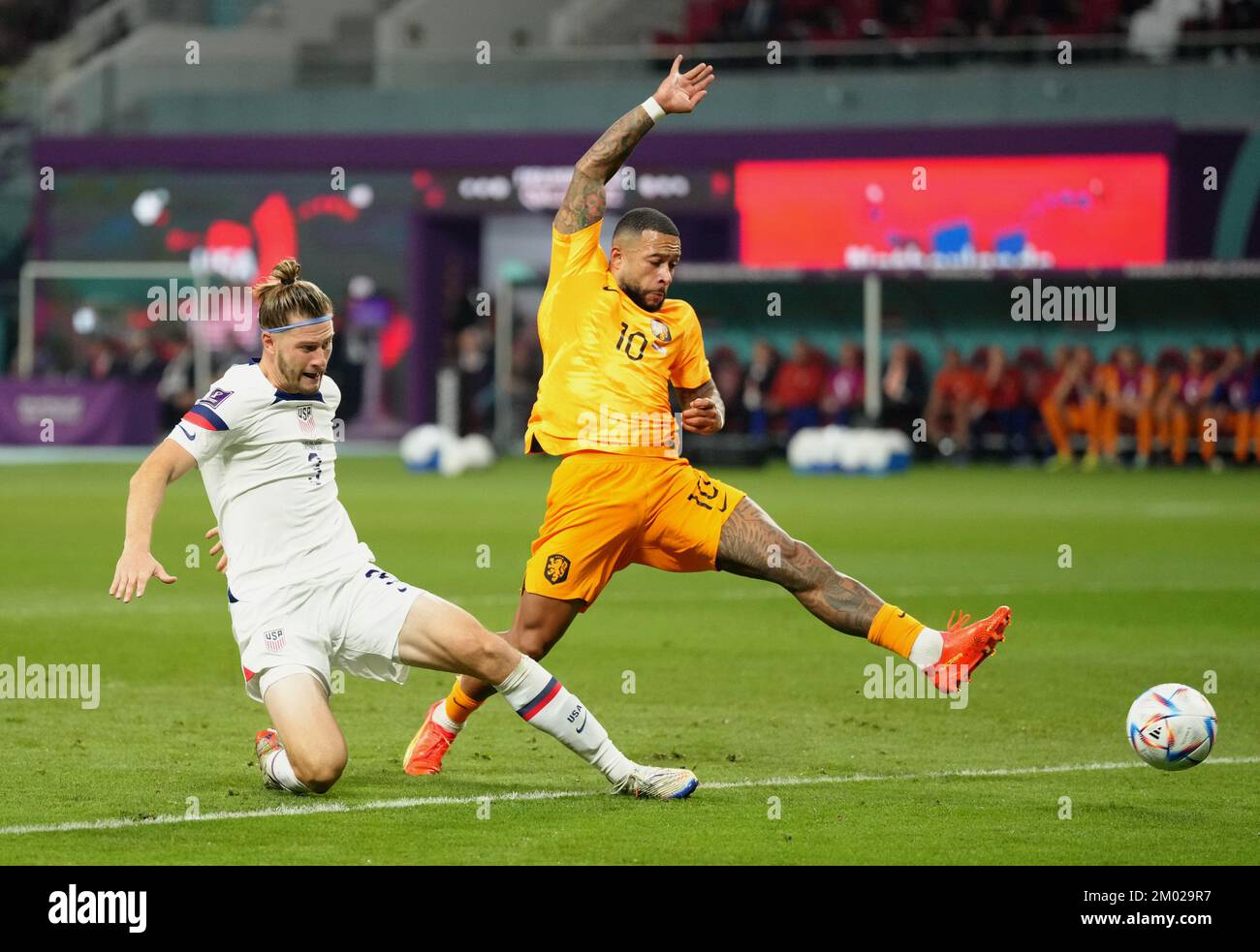 Netherlands' Memphis Depay fails to reach the ball under pressure from USA's Walker Zimmerman during the FIFA World Cup round of 16 match at the Khalifa International Stadium in Al Rayyan, Qatar. Picture date: Saturday December 3, 2022. Stock Photo