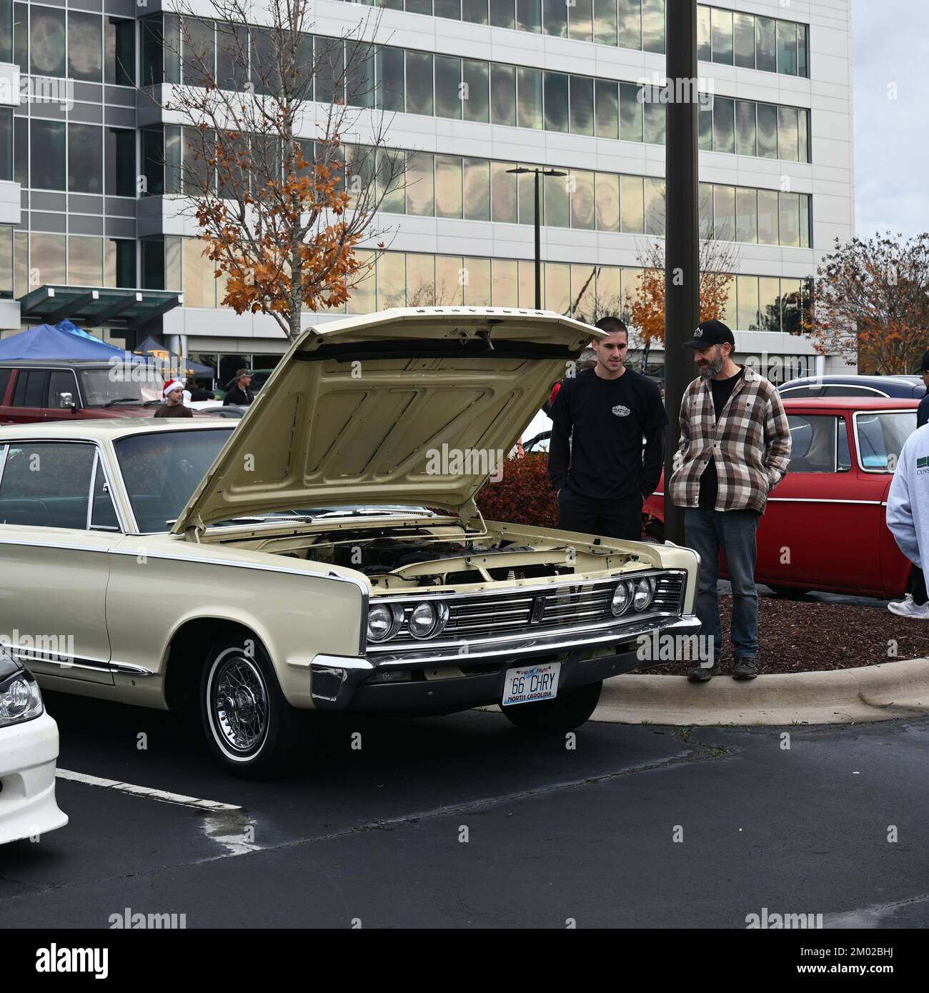 Durham, NC, USA, 3rd December 2022, Two men admire a classic Chrysler coupe at the monthly Cars and Coffee event. Credit D Guest Smith / Alamy Live News Stock Photo