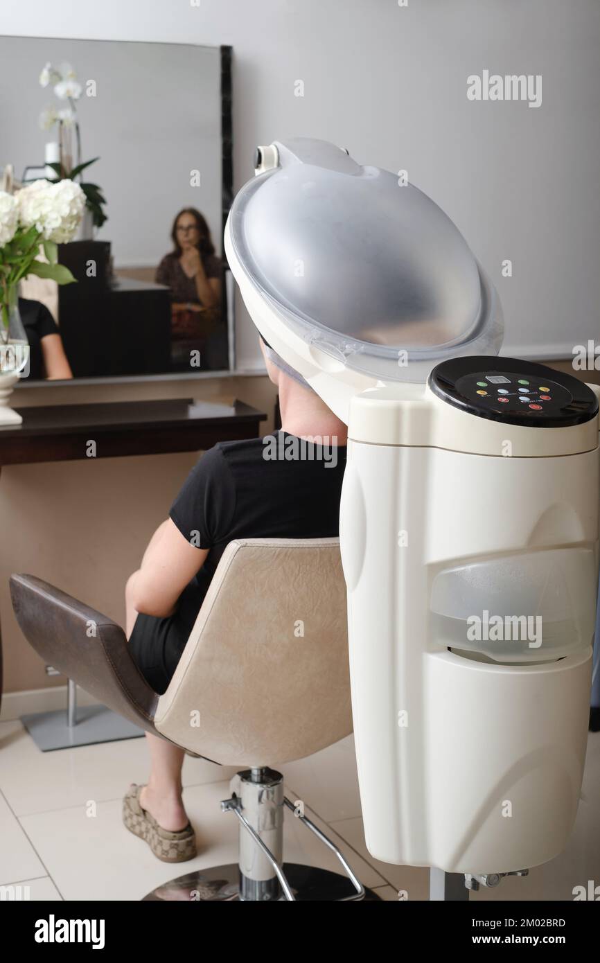 Hair professional treatment in salon. Using steam to dilate the pores of scalp. help to combat hair loss. Scalp cleansing. Woman visiting trichologist Stock Photo