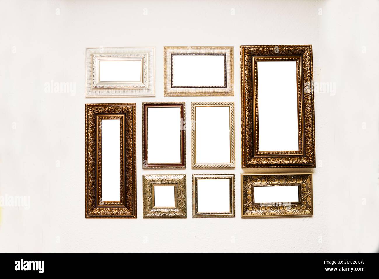 Different size framed photos hanging on the grey wall. Stock Photo