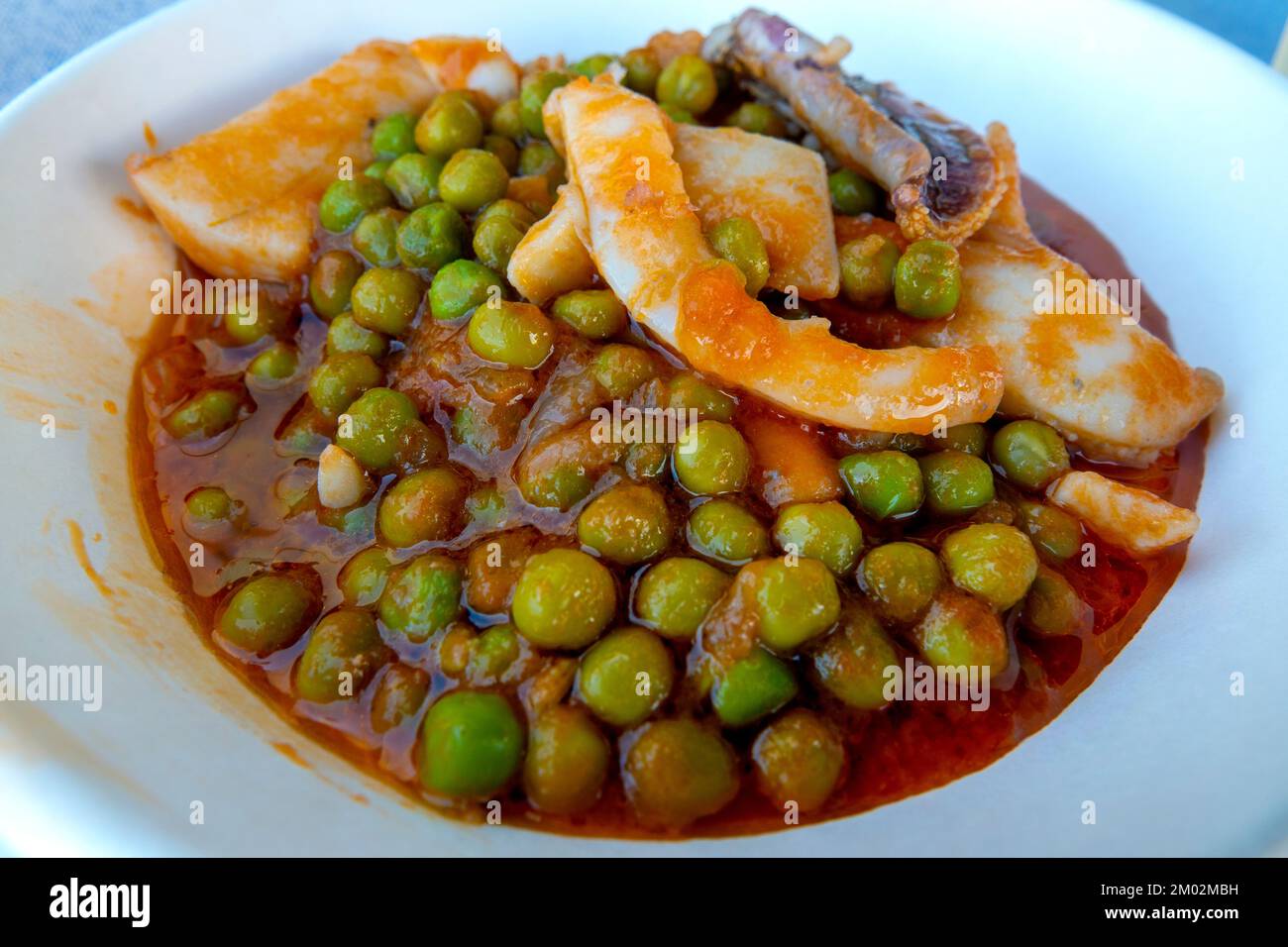 Cuttlefish with peas in tomato sauce Stock Photo